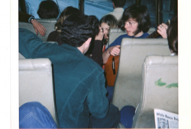Greg Graves playing guitar on bus to meet the ferry, AYA trip to Switzerland, Apr. 1972